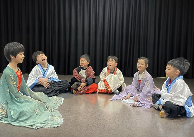 Students in costume seated in a circle