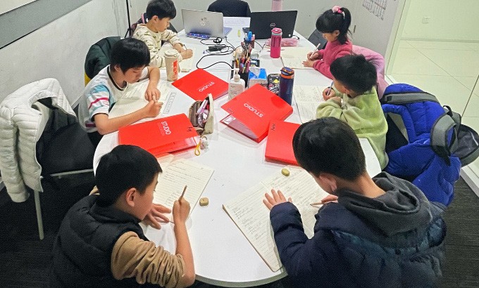 Students writing their scripts at the Studio Table