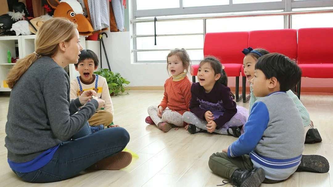 Early Years students in a circle with their teacher