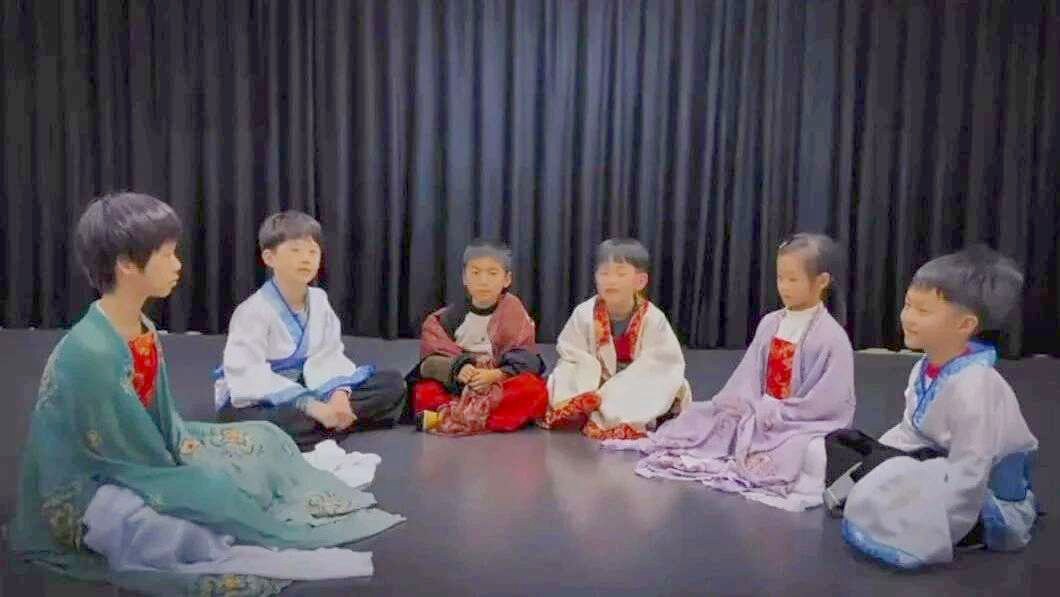 Students seated in a circle in costume